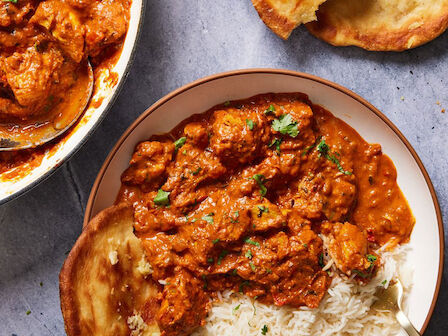 The image shows a plate of rice and spicy curry, with naan bread on the side, perfect for a delicious and flavorful meal.